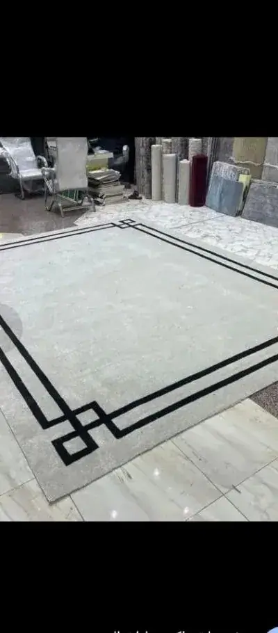 تشطيب حواف سجادة بإطار هندسي في الورشة بعد تفصيلها على المقاس